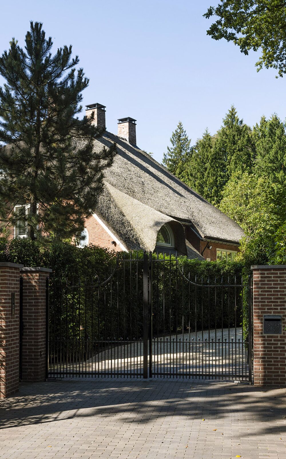 Smeedijzeren toegangspoort met klinkeroprit