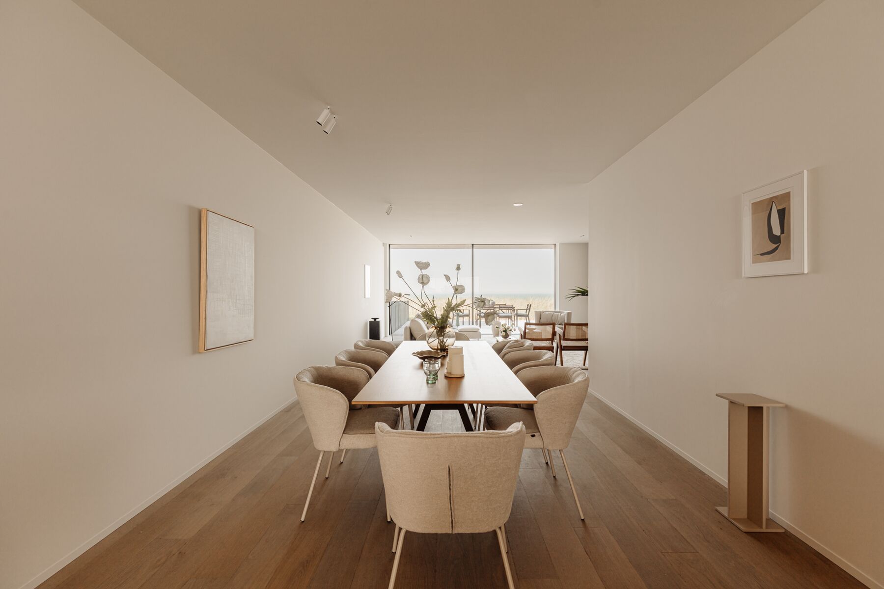 Lange eettafel in een lichte woonkamer met zicht naar buiten