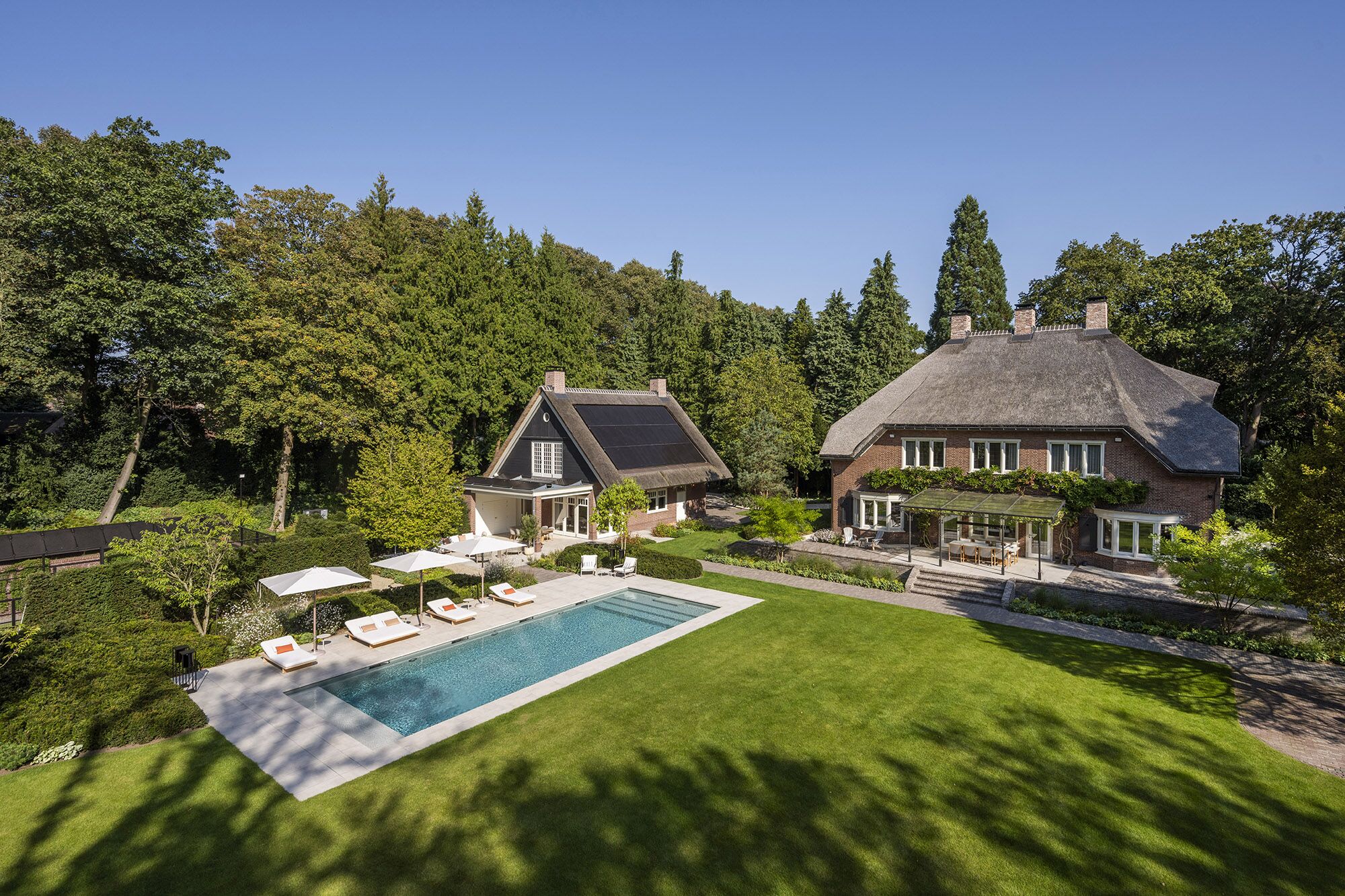 Landhuis met rieten kap, gazon en zwembad